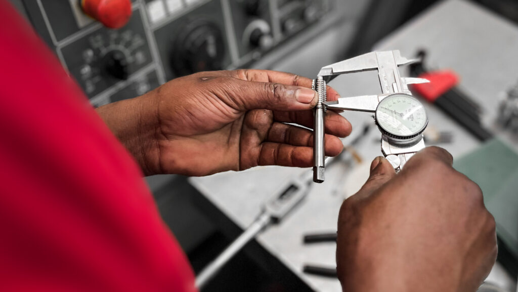 Qualified engineer precise measuring a custom machined parts to ensure the part is exactly according to spec